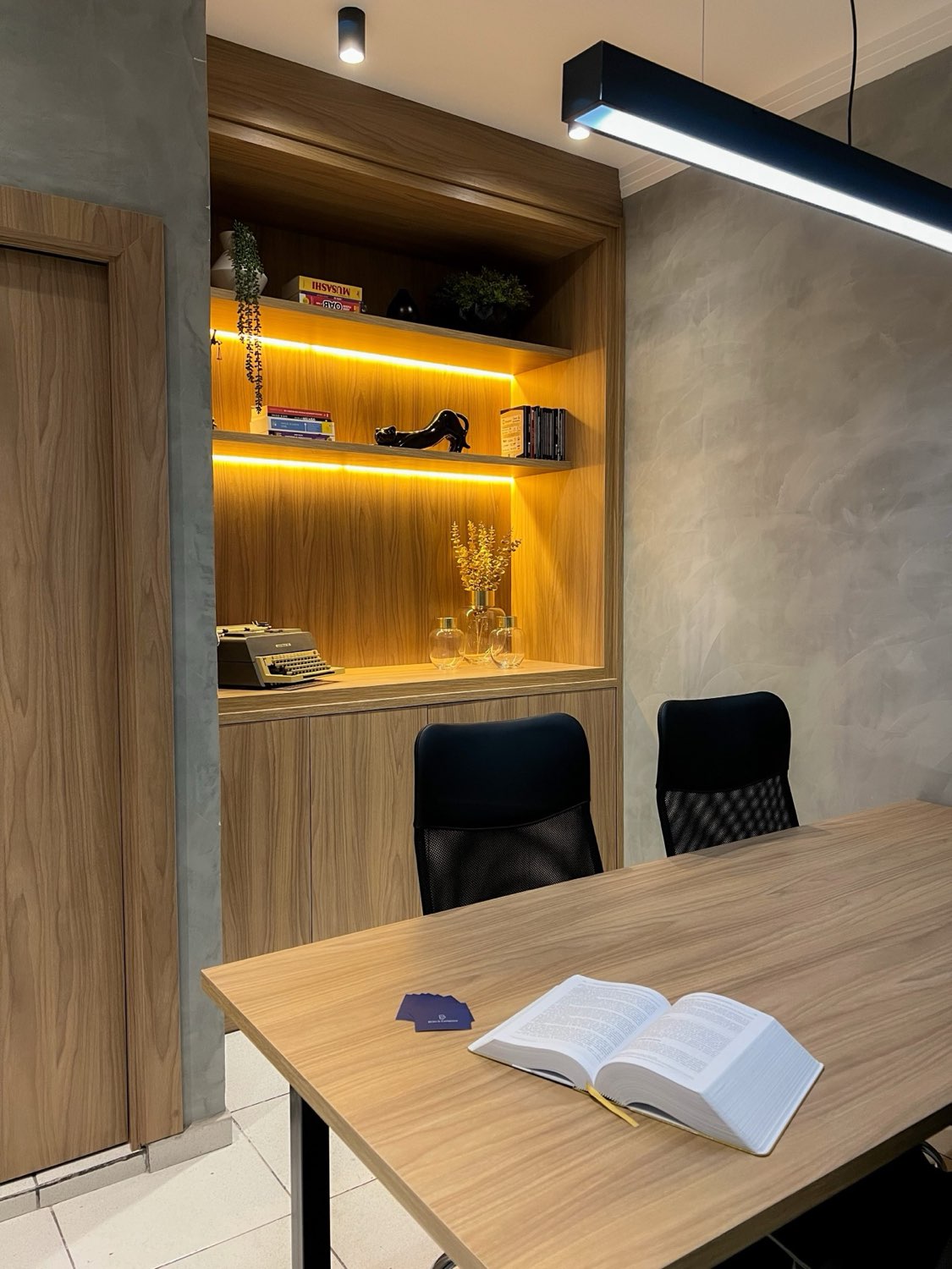 Mesa de reunião do escritório Brito & Campana Advogados, com livros jurídicos